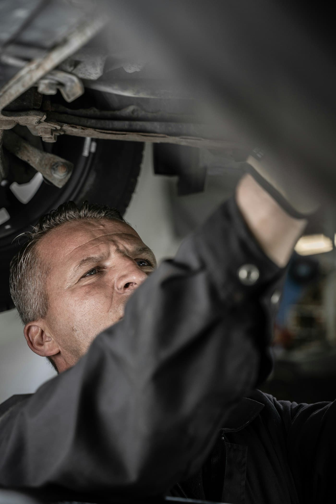 Our technician working under a customer vehicle on the lift at Prime Automotive Repair